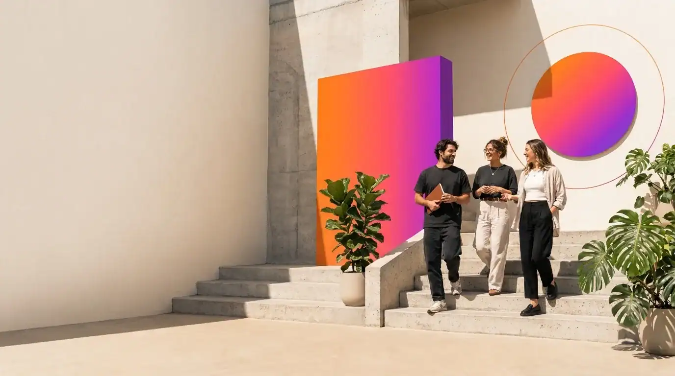 Three young colleagues chatting on a sunlit concrete stair beside a gradient wall